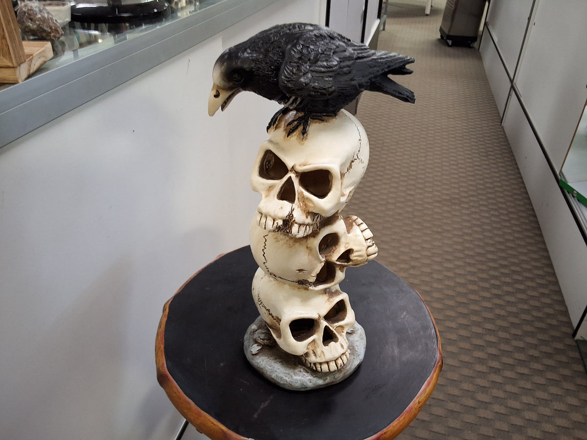 Three Stack Skulls With a Raven On Top