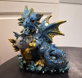 Little blue dragon holding egg with baby inside