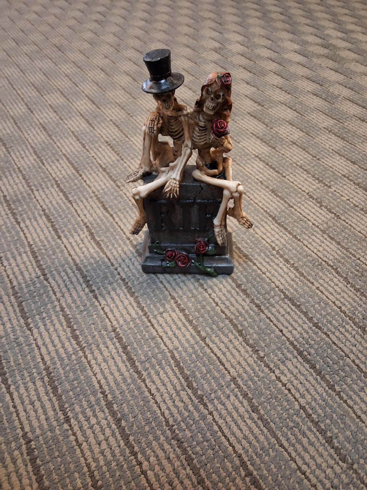 SKELETONS SITTING ON GRAVE STATUE