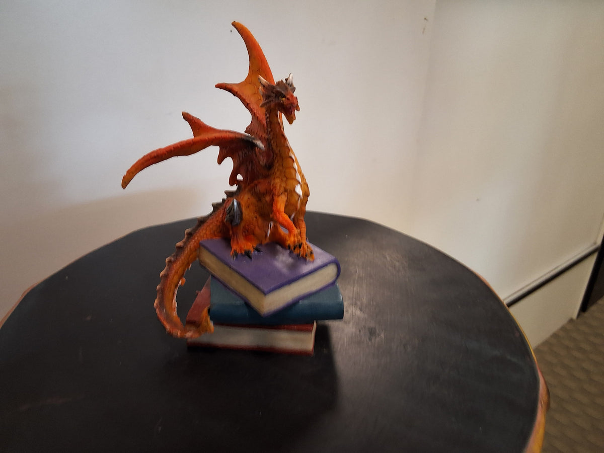 Orange dragon On Top Of Three Books